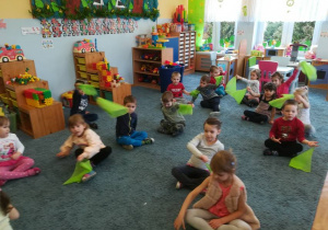 Dzieci siedząc na dywanie zielonymi chusteczkami ilustrują utwór „Wiosna” op.74 nr 2 Fryderyka Chopina.